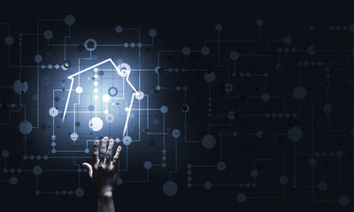 Conceptual image with hand pointing at house or main page icon on dark background