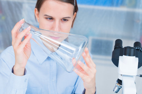 student girl with glass empty Conical flask in hand