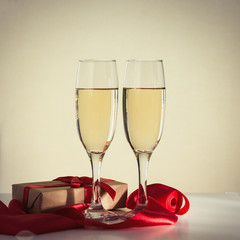   Packaged gift, two glasses of champagne and a red ribbon