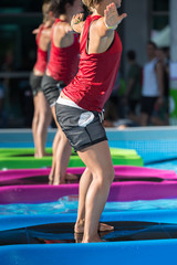 Fototapeta na wymiar Girls Doing Exercises on Floating Fitness Mat in an Outdoor Swimming Pool