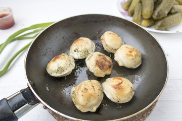 Fried dumplings in a frying pan.