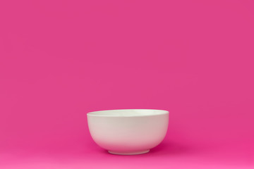 close-up view of single empty white bowl ready for breakfast isolated on pink