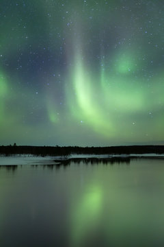 Aurora borealis over a lake in winter, Finnish Lapland
