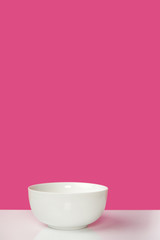 close-up view of single empty white bowl on pink