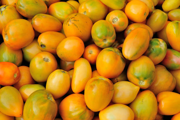 closeup of fresh yellow tomatoes as a background