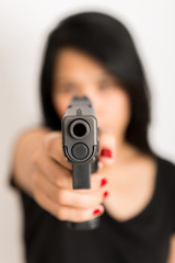 young woman asian girl holding a gun aiming at the gun, with selective focus