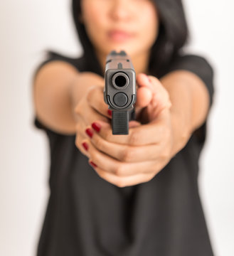 young woman asian girl holding a gun aiming at the gun, with selective focus