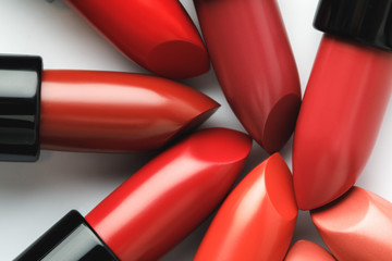 close-up shot of red lipsticks of different shades on white tabletop - obrazy, fototapety, plakaty