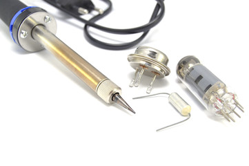 Radio components and electric soldering iron on white background close-up 