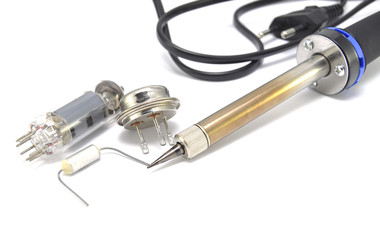 Radio components and electric soldering iron on white background close-up 