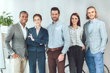 Fototapeta premium smiling multicultural businesspeople standing and looking at camera