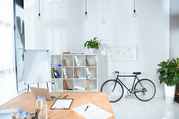 view of empty office interior with table and bicycle against wall