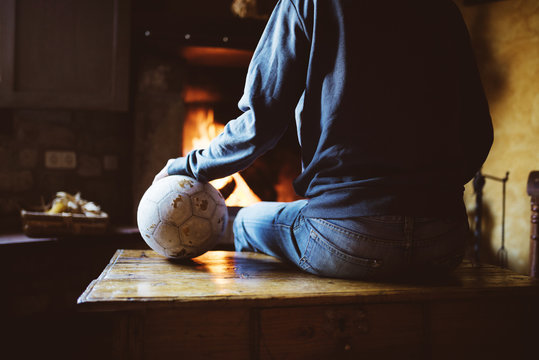 Man sitting in front of the fireplace with a soccer ball