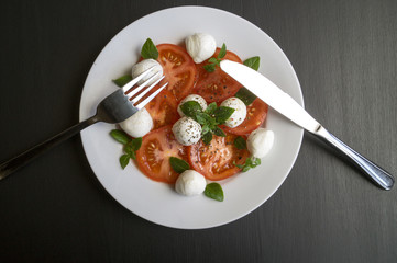 Caprese salad with ripe tomatoes and mozzarella with fresh Basil