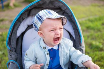 Little boy crying in a stroller