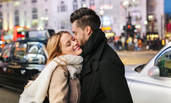 UK, London, young man kissing his girlfriend