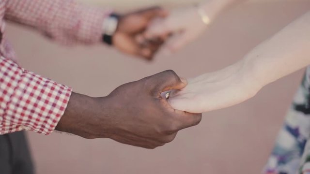 tolerance theme . interracial couple holding hands