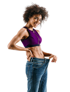 Young girl delighted with her dieting results. Photo of young african girl isolated on white background. Strength and motivation