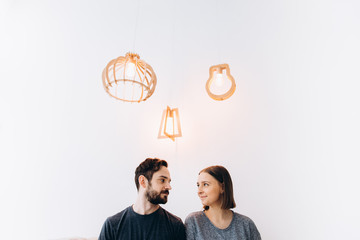 Lovers looking in each other's eyes. Love story. White background, three lamps, side view