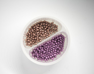 Beautiful colorful jewelry making beeds on white background. Shallow depth of field. Hand craft supplies.
