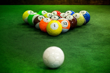 Shot of foot pool balls standing on green table. Foot Pool is the hybrid combination of pool and soccer. Big billiard balls