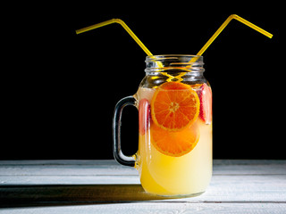 Orange lemonade against a dark background. Summer soft drinks
