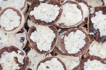Preparing mushrooms for barbecue on holiday. Mushrooms with cheese spread in bowl. Cooking vegetables. Delicious meal for vegetarians and vegans