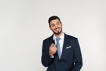 cheerful young businessman pointing at camera isolated on grey