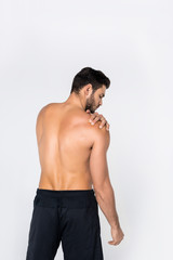 Fototapeta na wymiar back view of young shirtless man with pain in shoulder isolated on white