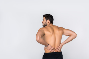 back view of young shirtless man with back pain isolated on white