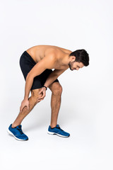 Obraz premium sportive young man with knee pain on white