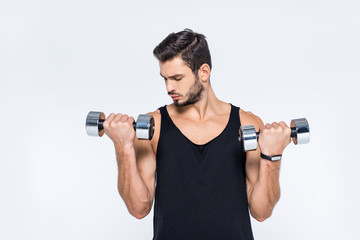 Fototapeta na wymiar handsome young man working out with dumbbells isolated on white