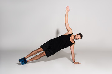 sportive young man doing side plank