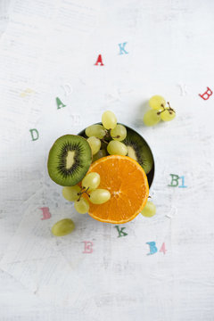 Banane, apple, orange, kiwi and green grapes, different vitamins