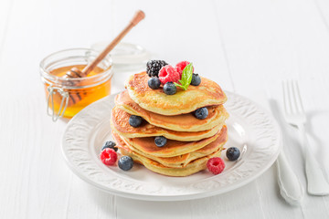 Sweet and tasty american pancakes with maple syrup and berries