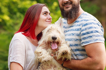 Close up of couple holding a dog