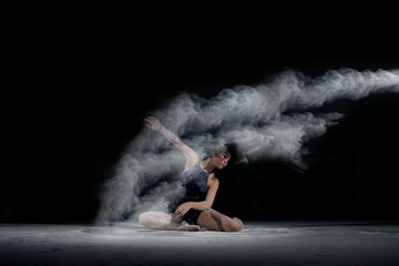 Girl dancing in the flour on the black background