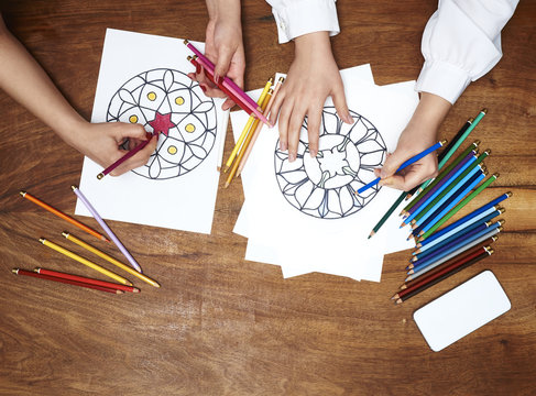 Hands drawing mandalas