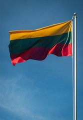 Lithuanian national flag with a blue sky in background
