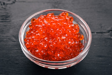 Red salmon caviar. On a wooden background. Top view. Free space for text.
