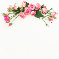 Floral frame of flowers, copy space. Spring composition with pink roses on white background. Top view. Flat lay.