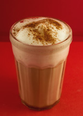 delicious cappuccino in a transparent glass, covered with cinnamon