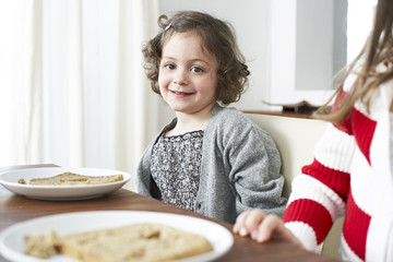 Portrait of smiling little girl at dining table