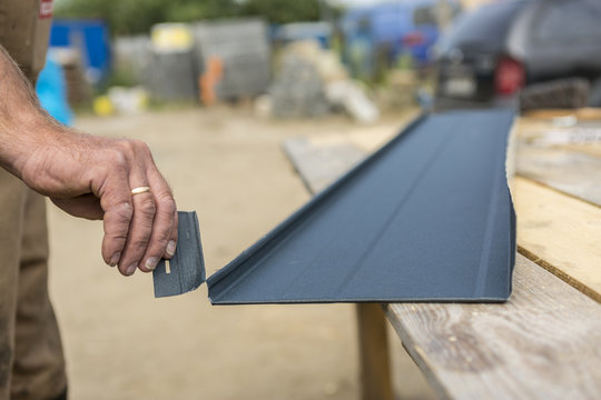 dłoń trzymająca odcięty kawałek blachy