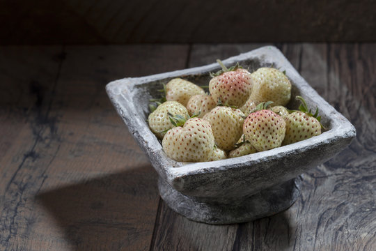 Bowl of pineberries on wood
