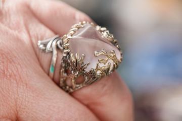 Macro shot of silver engagement ring on colorful, sparkling background. Rose Quartz Crystal is rose pink colored quartz that aids all types of relationships. powerful healing crystal