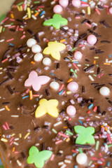 Closeup of birthday cake icing with colourful decoration – from above