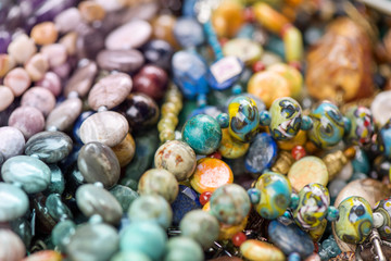 Macro shot of rhodochrosite stone, jasper, glass, hrizokola stones. Gemstone bracelets and necklaces in a row. Healing, powerful energy for crystal therapy treatments and reiki. Esoteric background