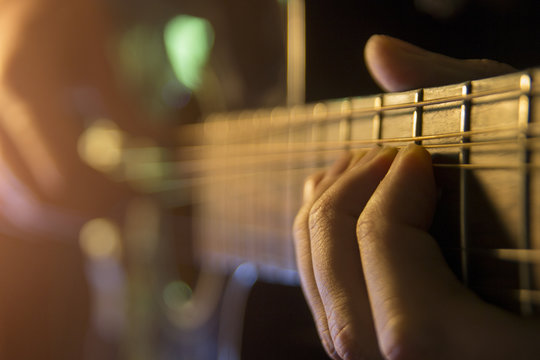 Man is playing the guitar, close up