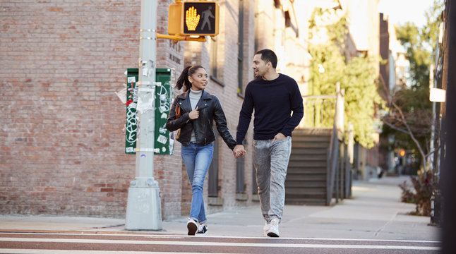 Young Hispanic couple walking hand in hand in Brooklyn